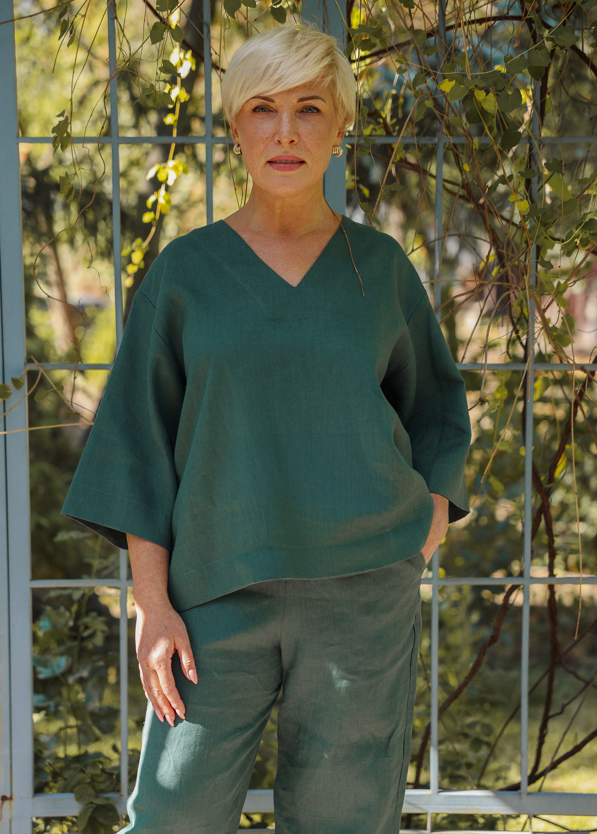 a woman standing in front of a metal fence