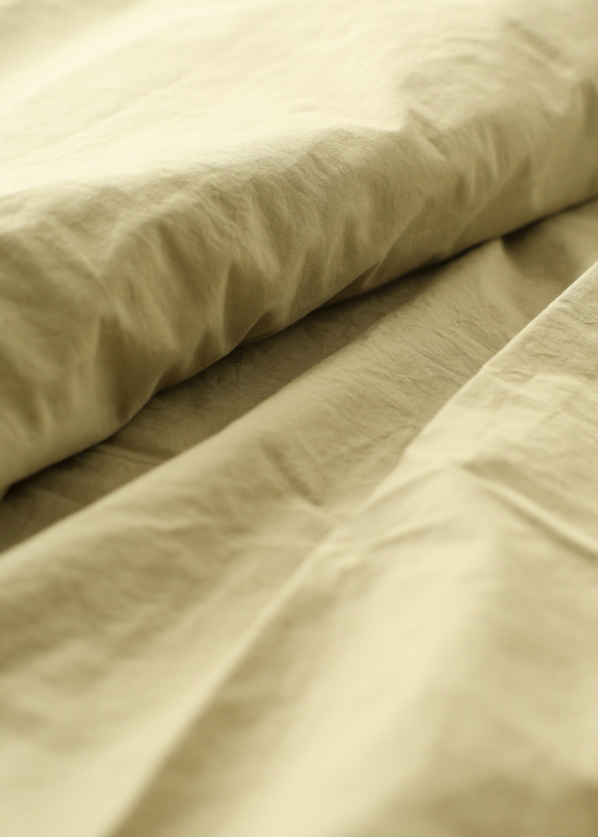 a close up of a bed with a white comforter