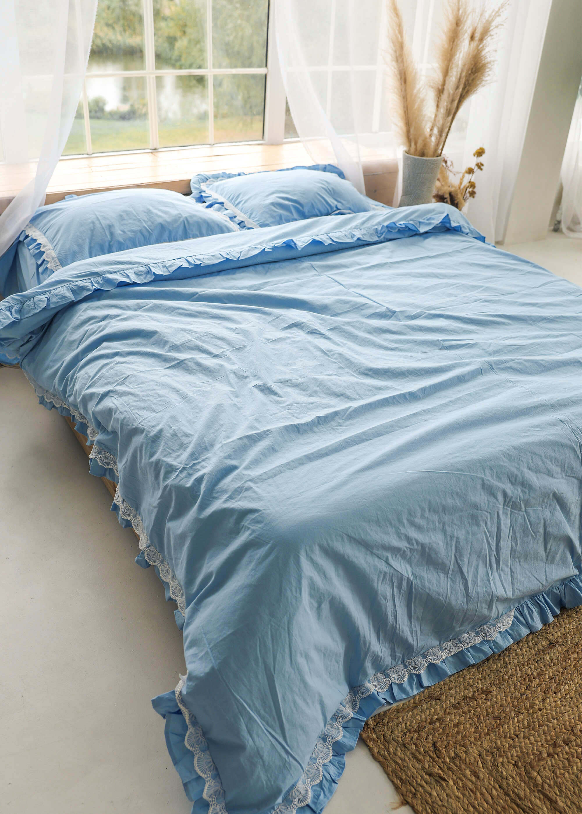 a bed with a blue comforter and pillows