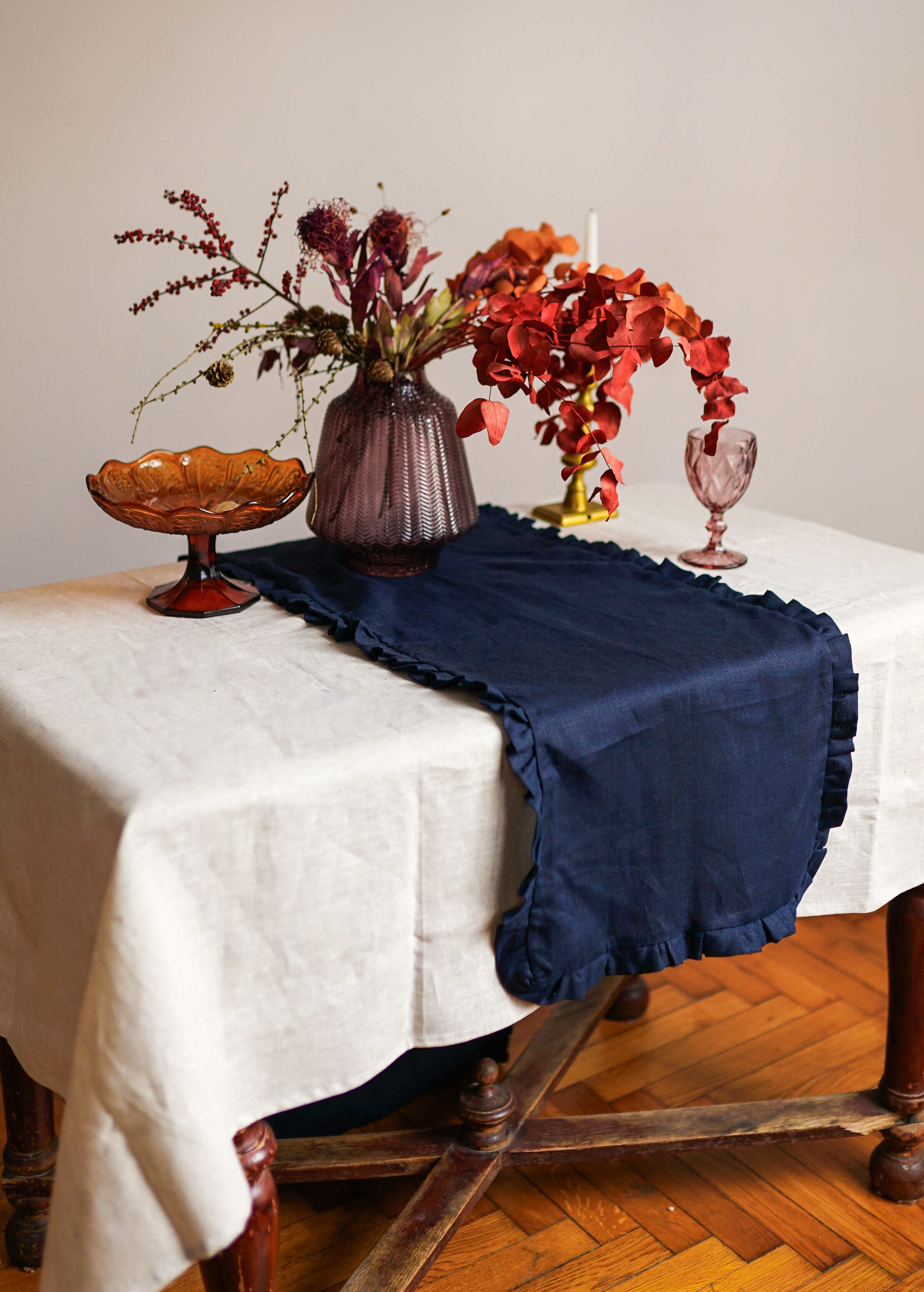 a table topped with a white table cloth and a vase filled with flowers