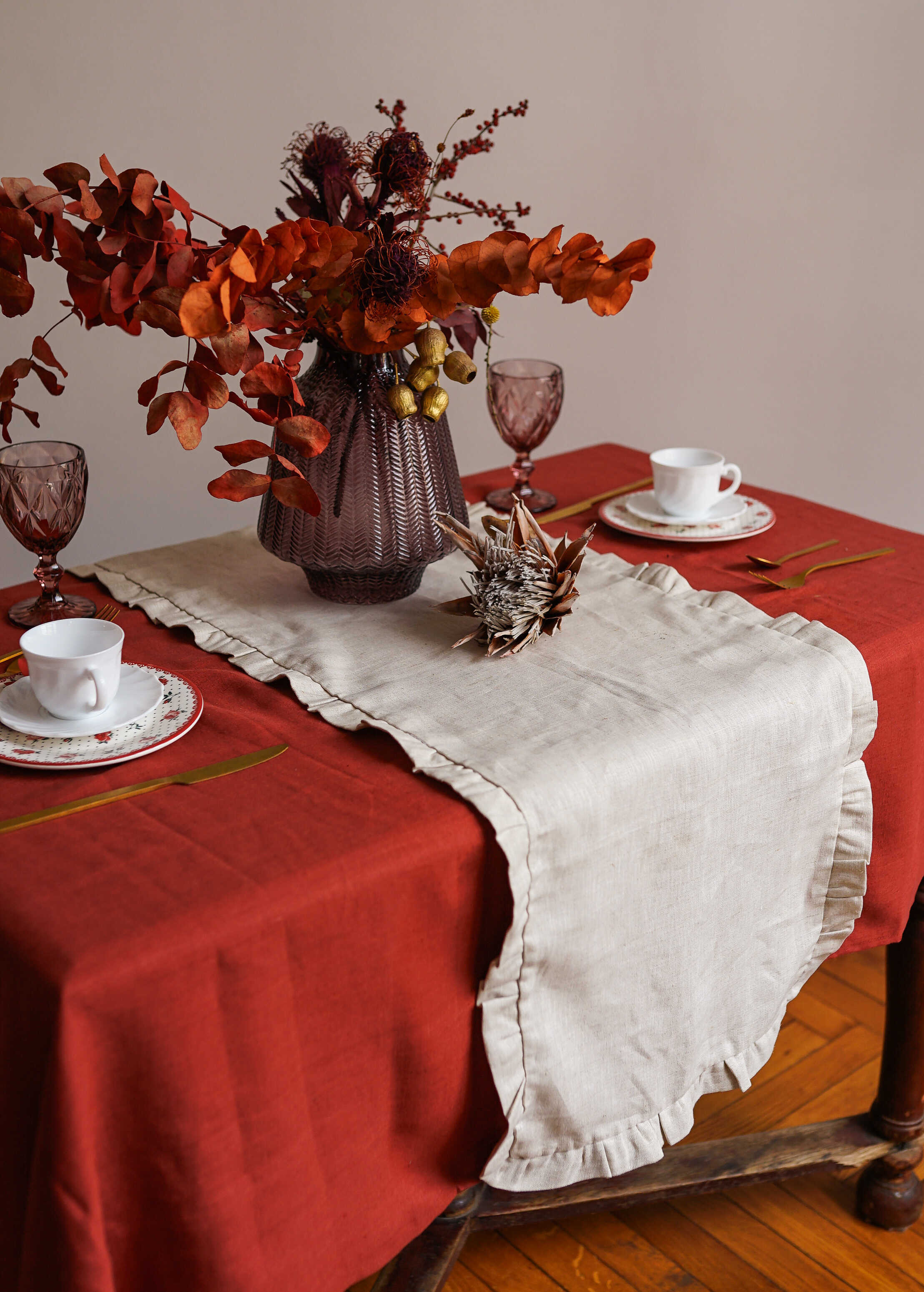 a table topped with a vase of flowers and a plate