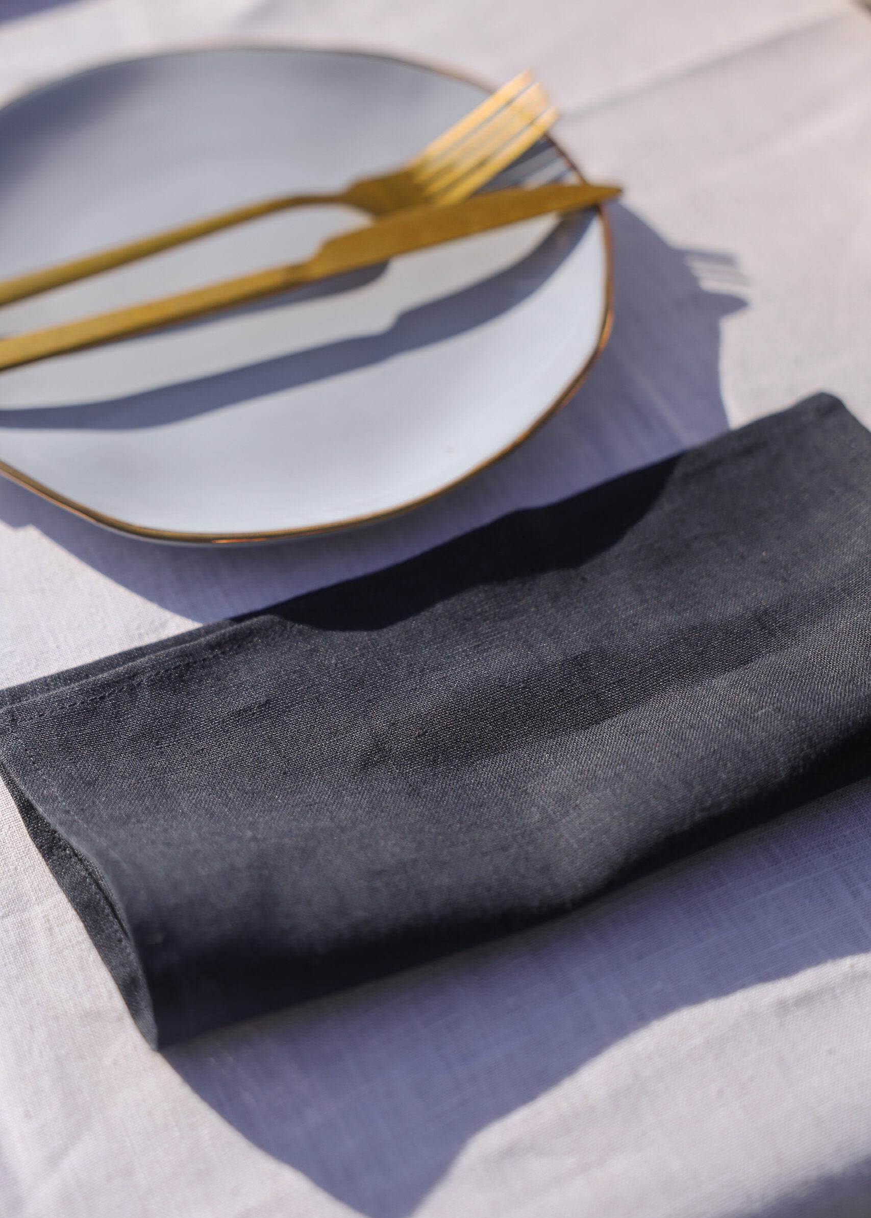 a white plate with a black napkin and a gold fork