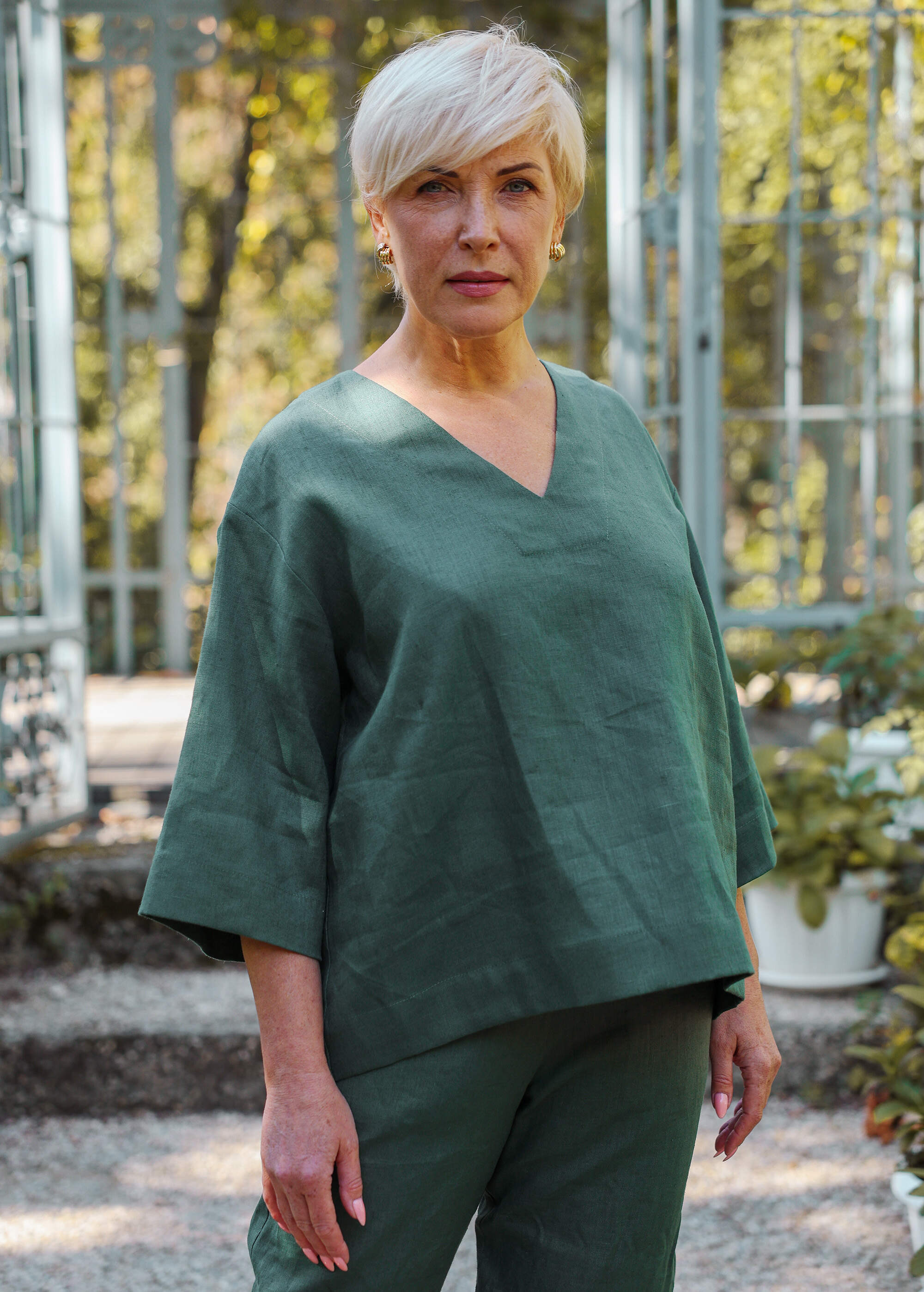 a woman in a green top is standing outside