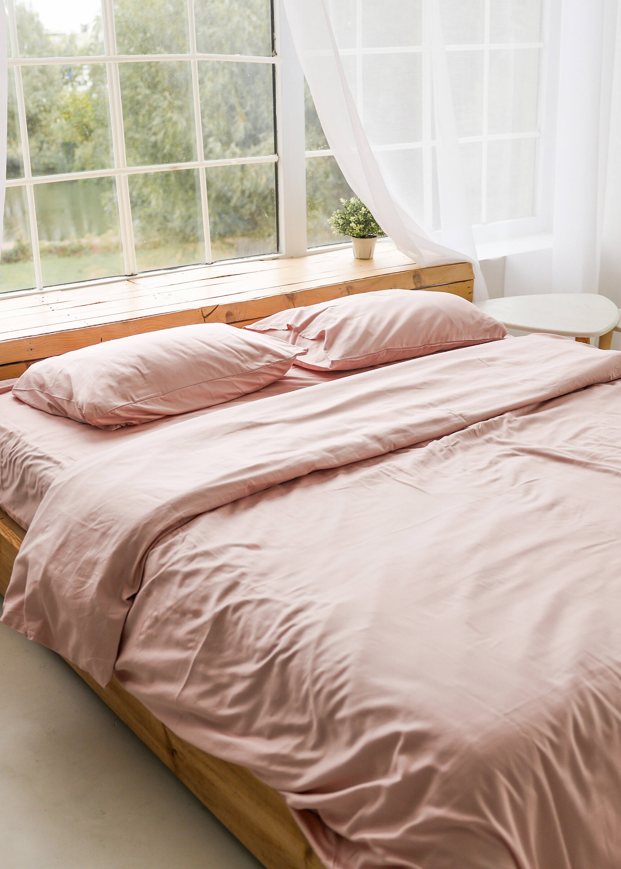 a bed with a pink comforter and pillows