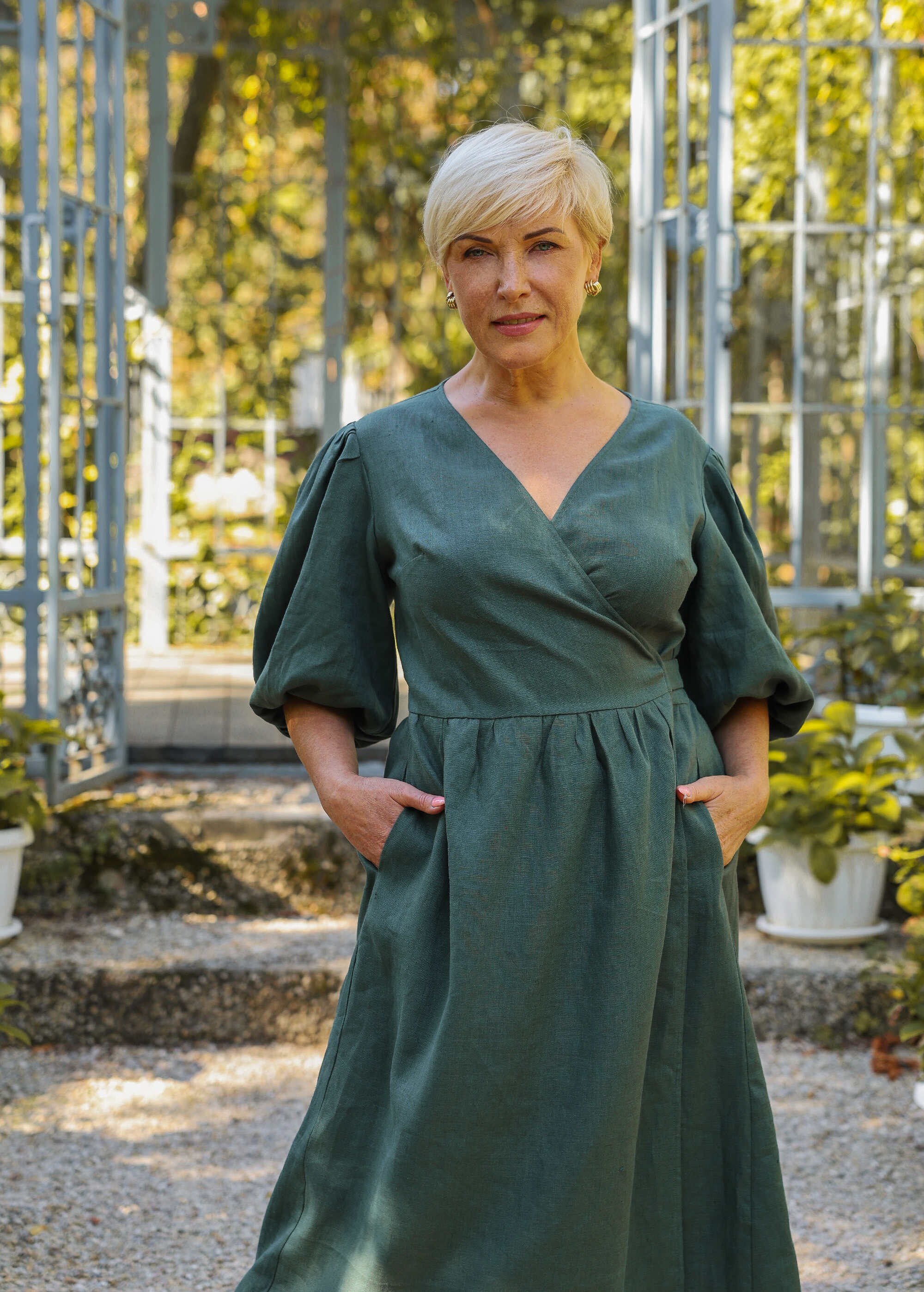 a woman in a green dress standing in a garden