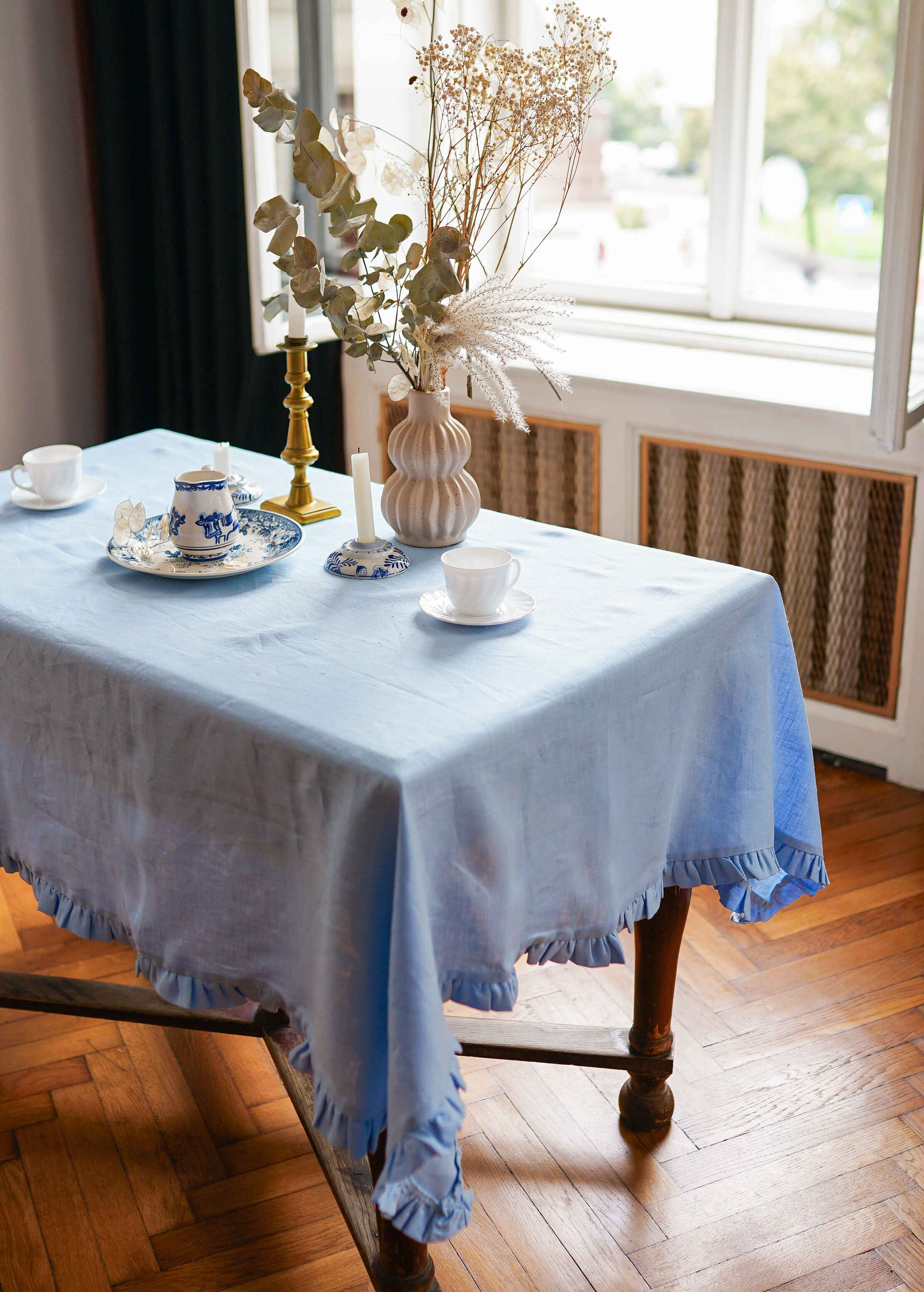 a table with a blue table cloth and a vase with flowers