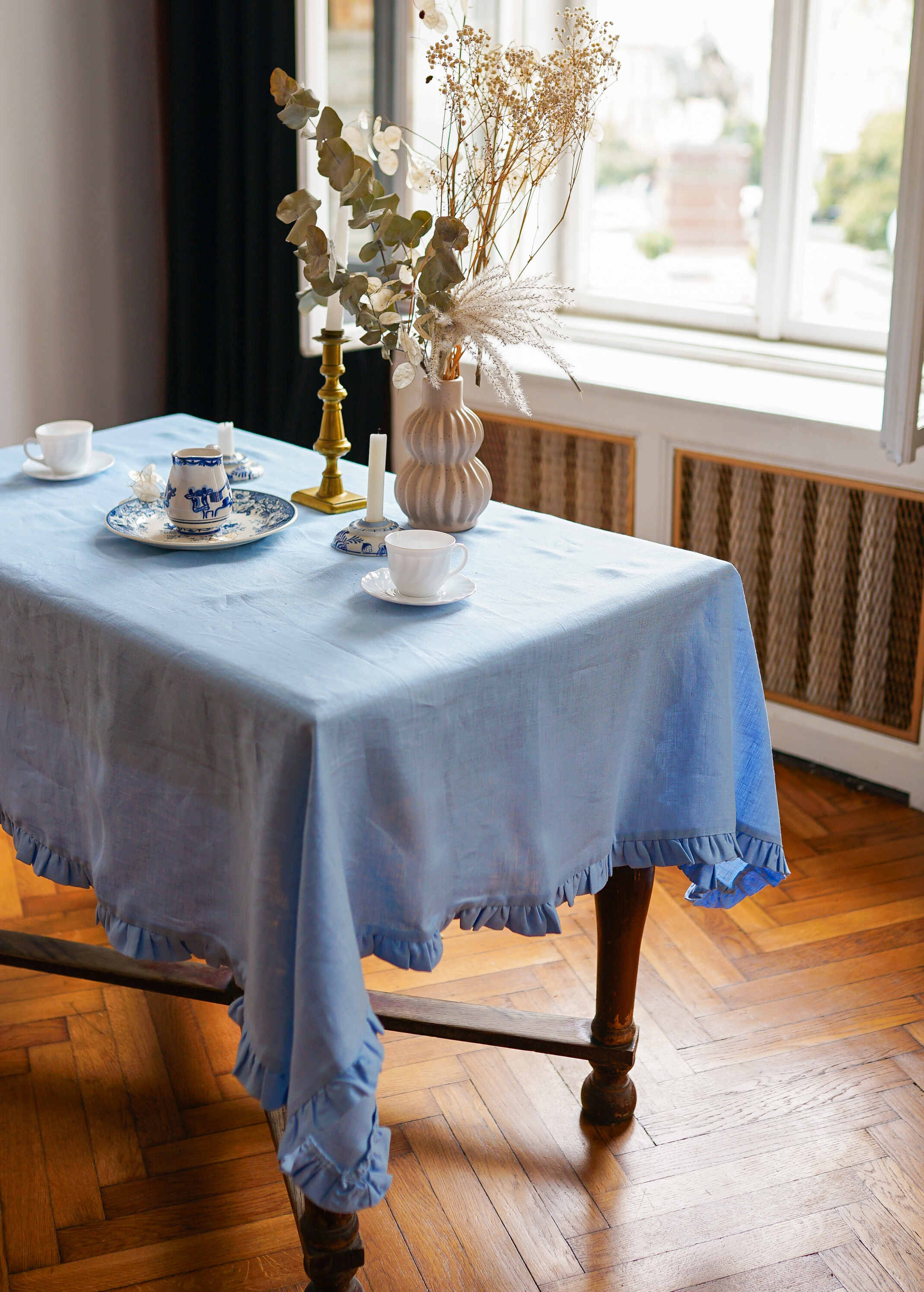 a table with a blue table cloth and a vase of flowers