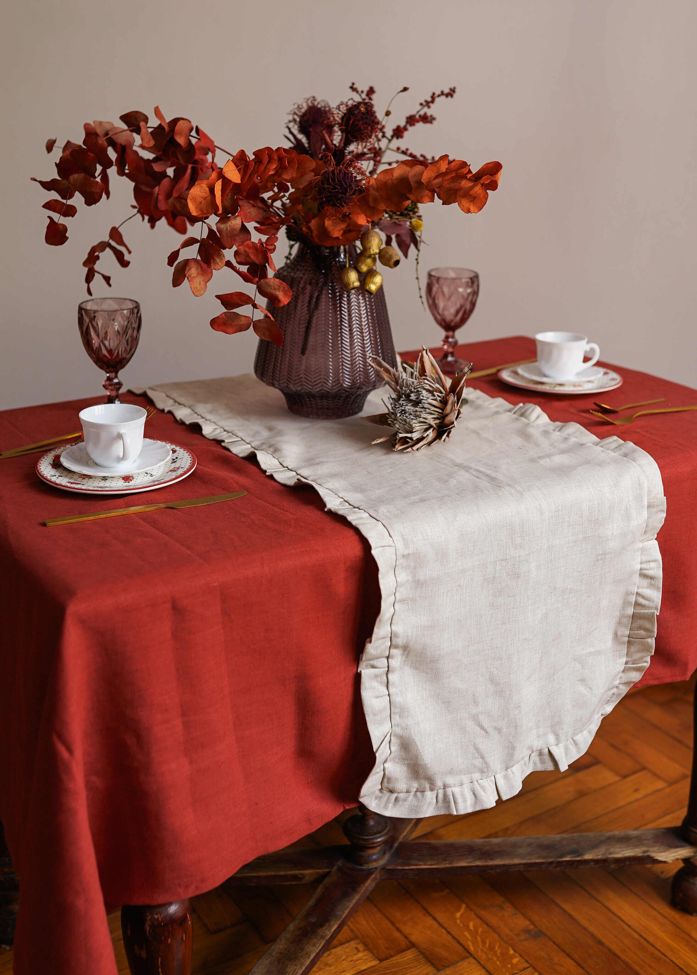 a table with a red table cloth and a vase of flowers