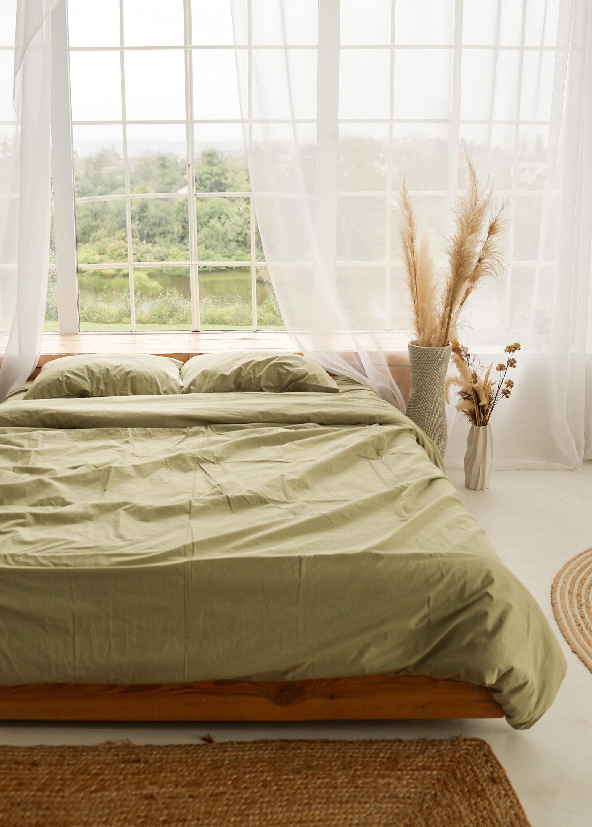 a bed sitting in a bedroom next to a window