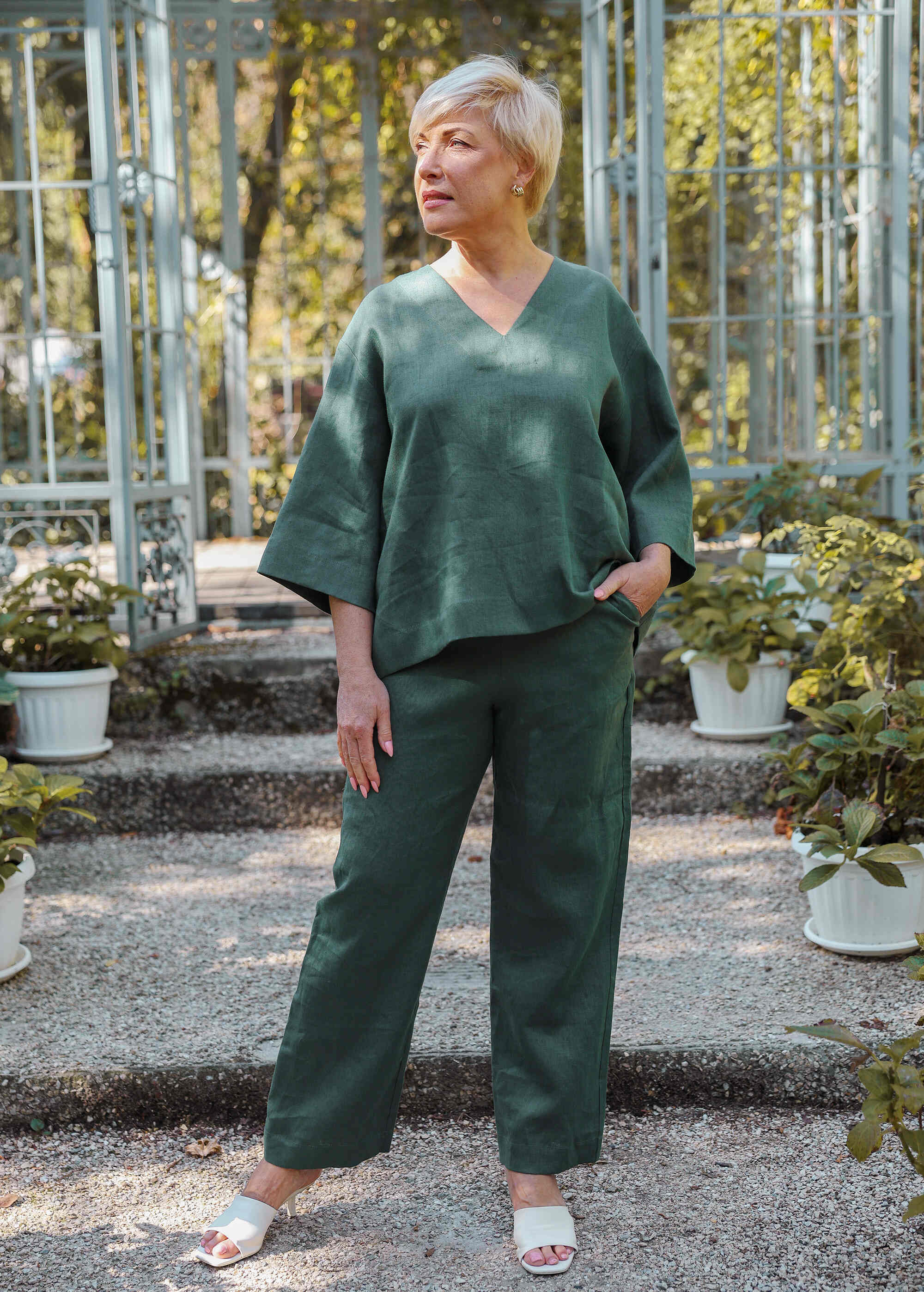 a woman standing in front of a greenhouse