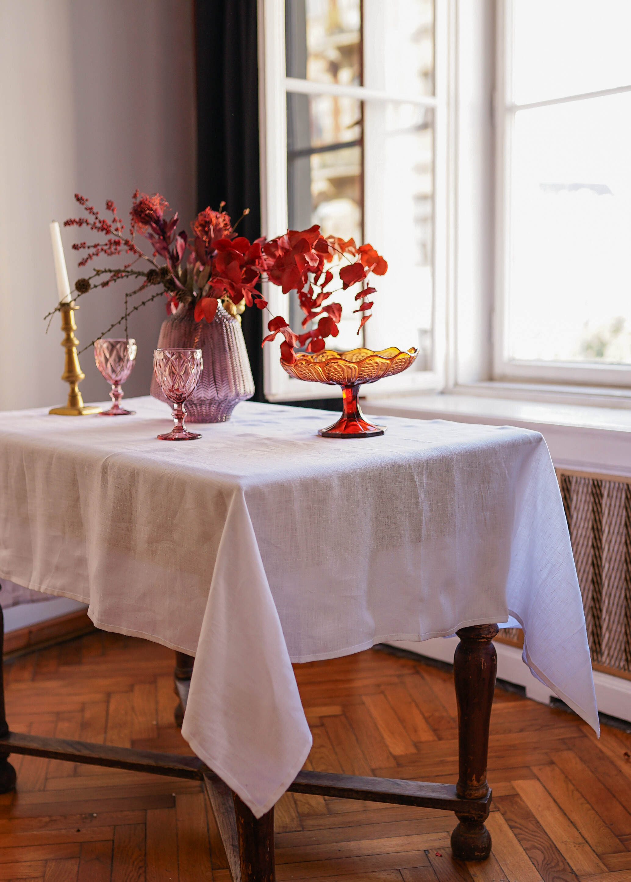 a table with a white table cloth and vases of flowers