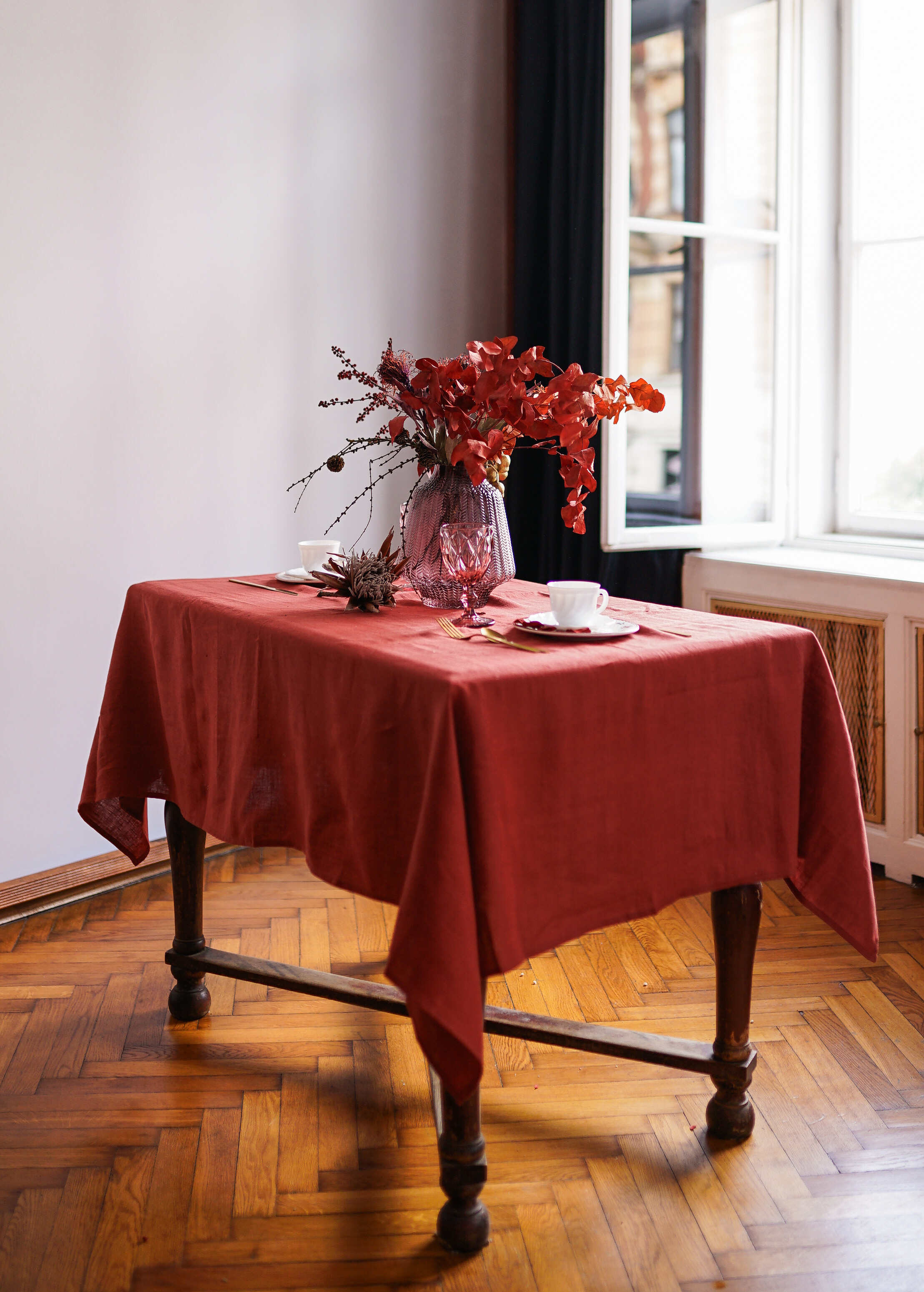 a table with a red table cloth and a vase of flowers