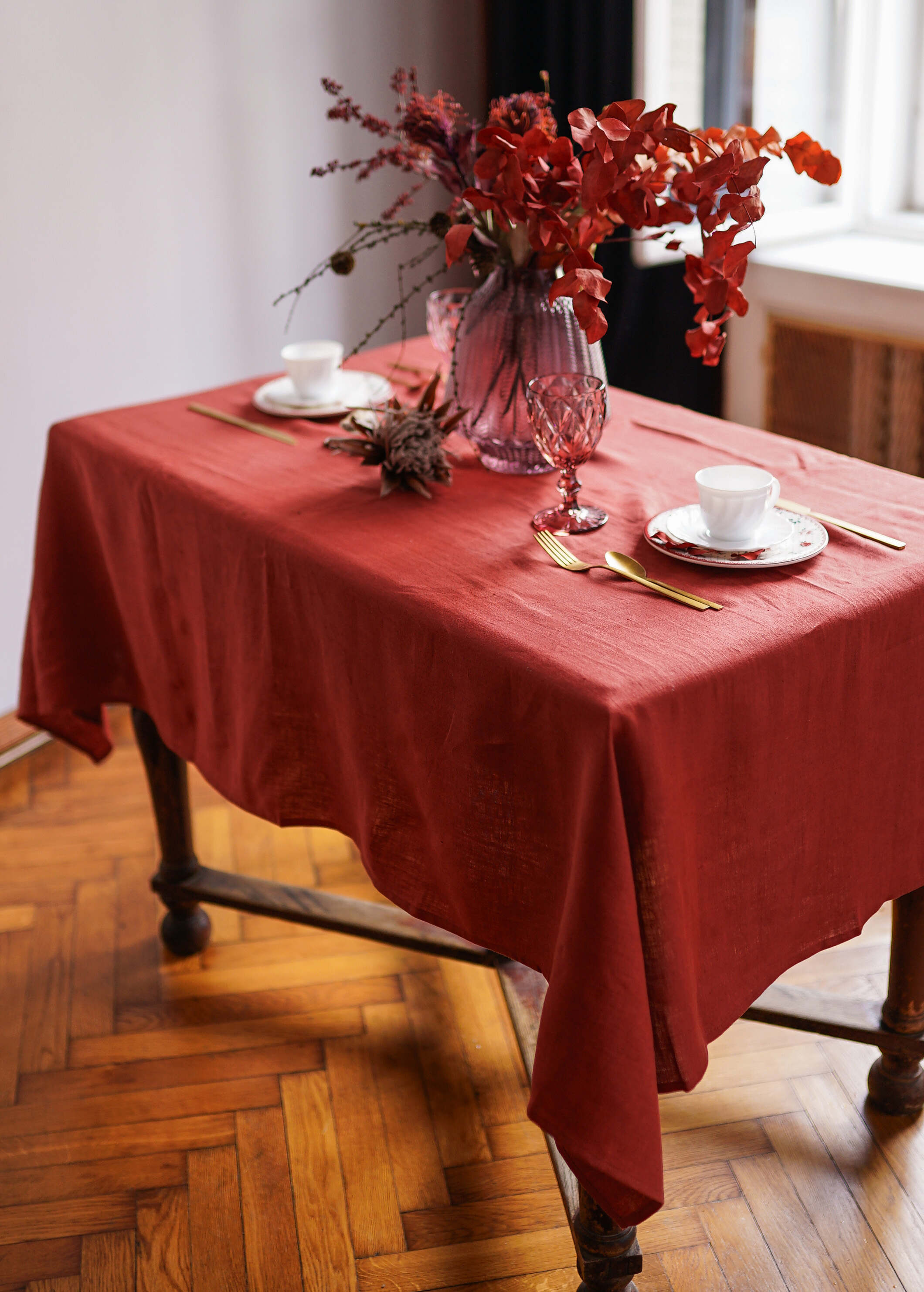 a table with a vase of flowers and plates on it