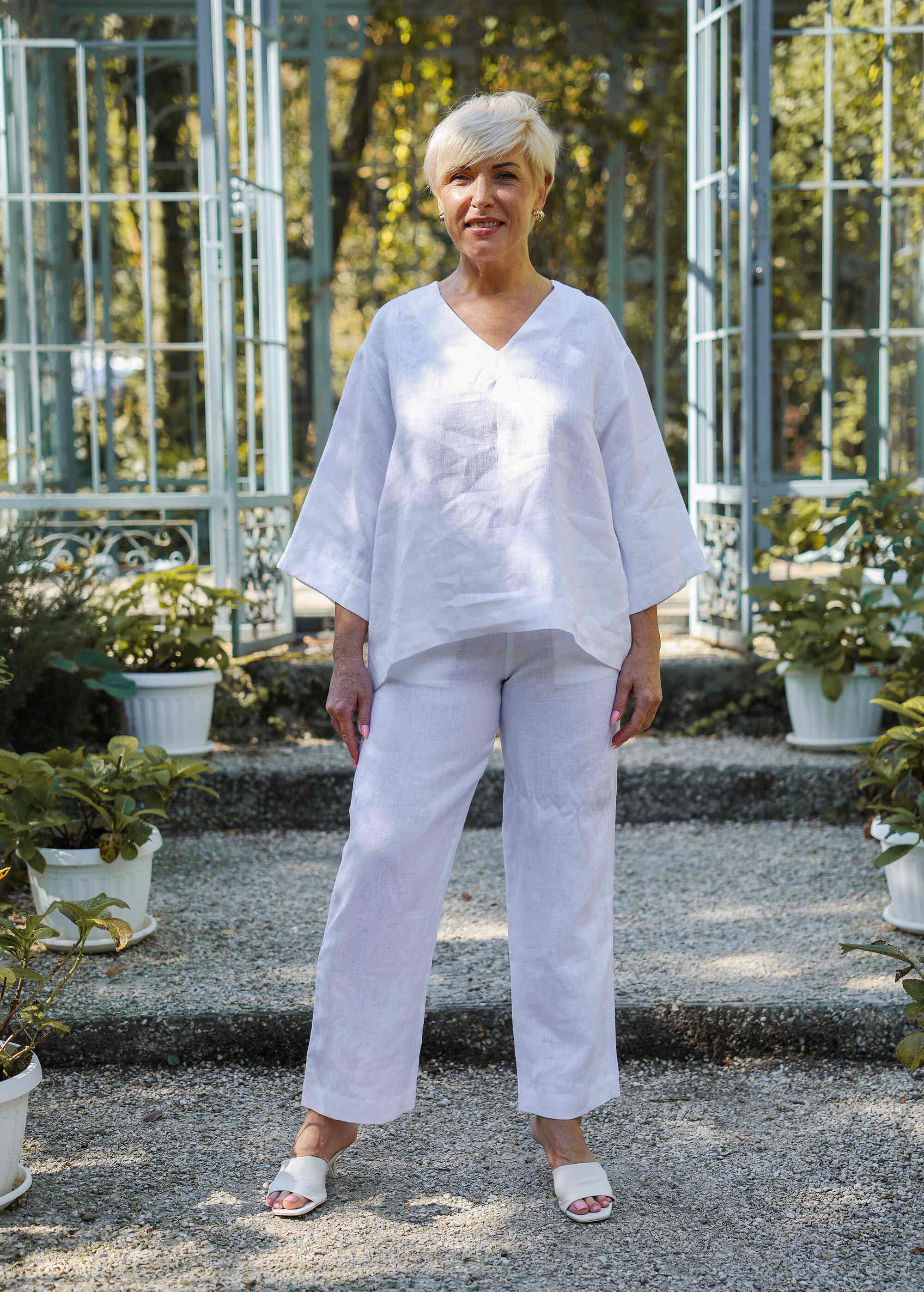 a woman standing in front of some potted plants