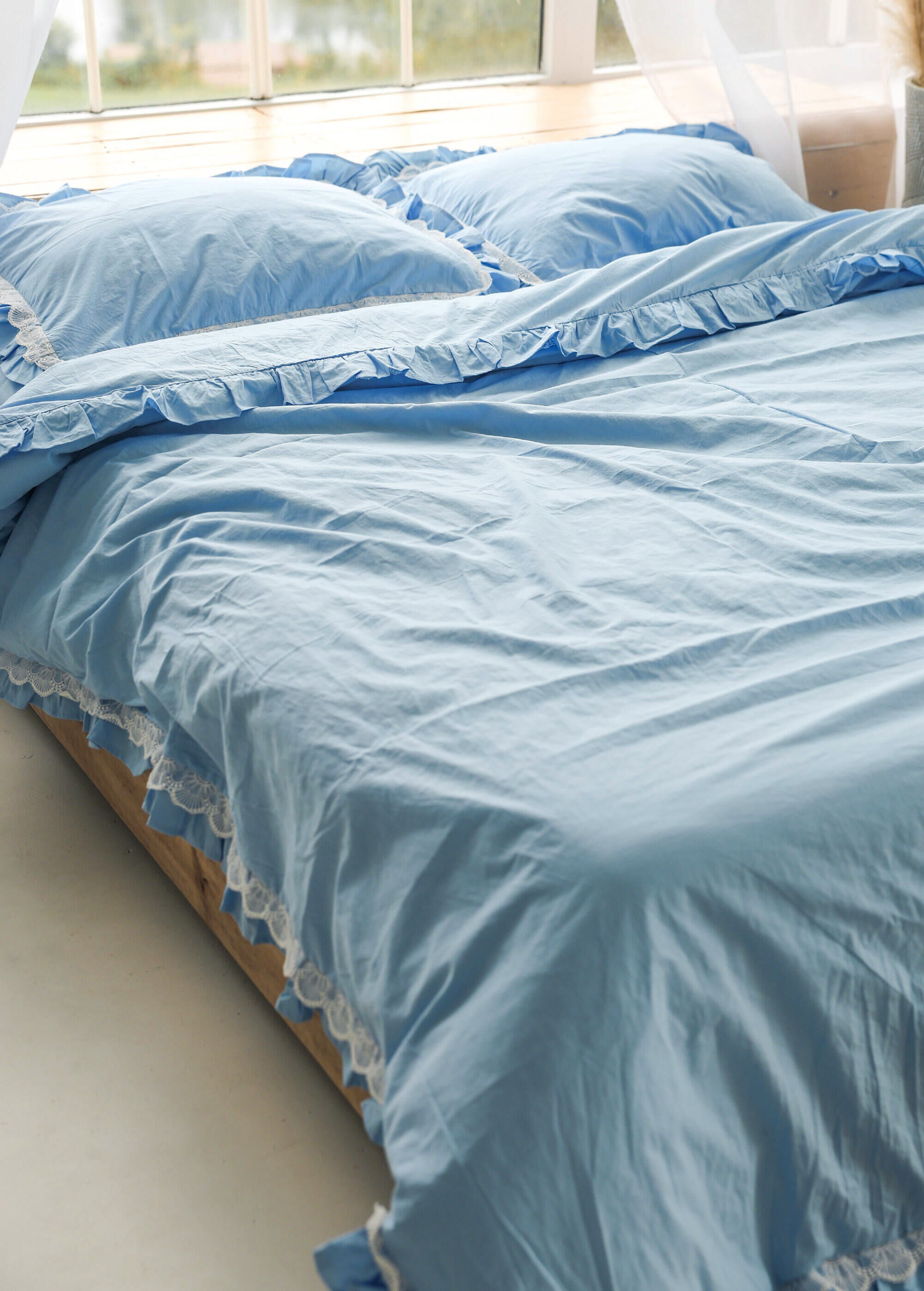 a bed with a blue comforter and two pillows