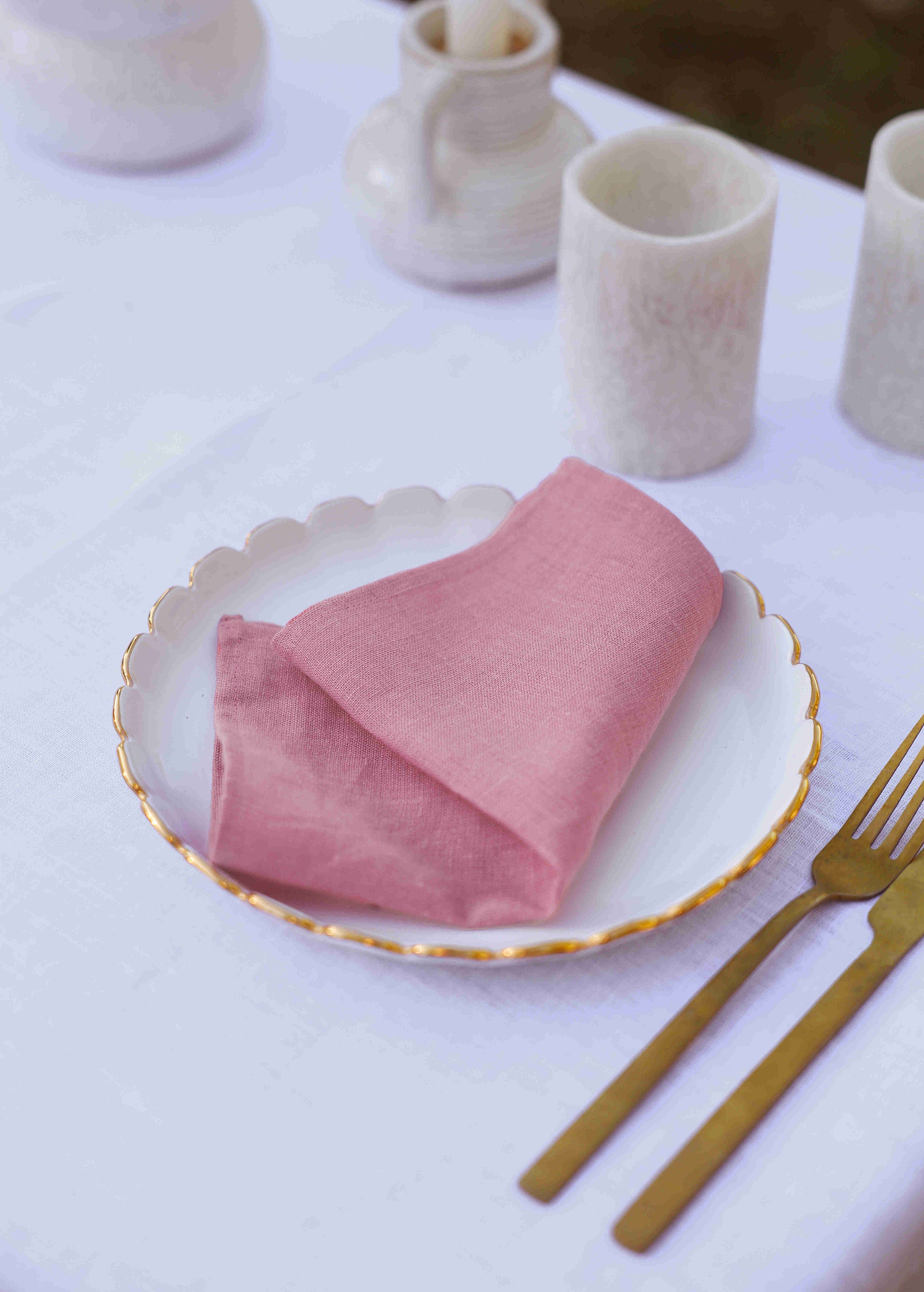 a white table with a pink napkin on it