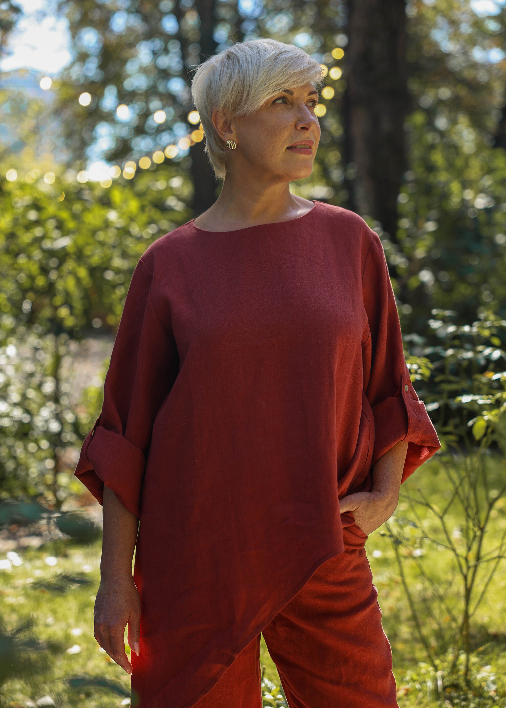 a woman in a red top is standing in the grass