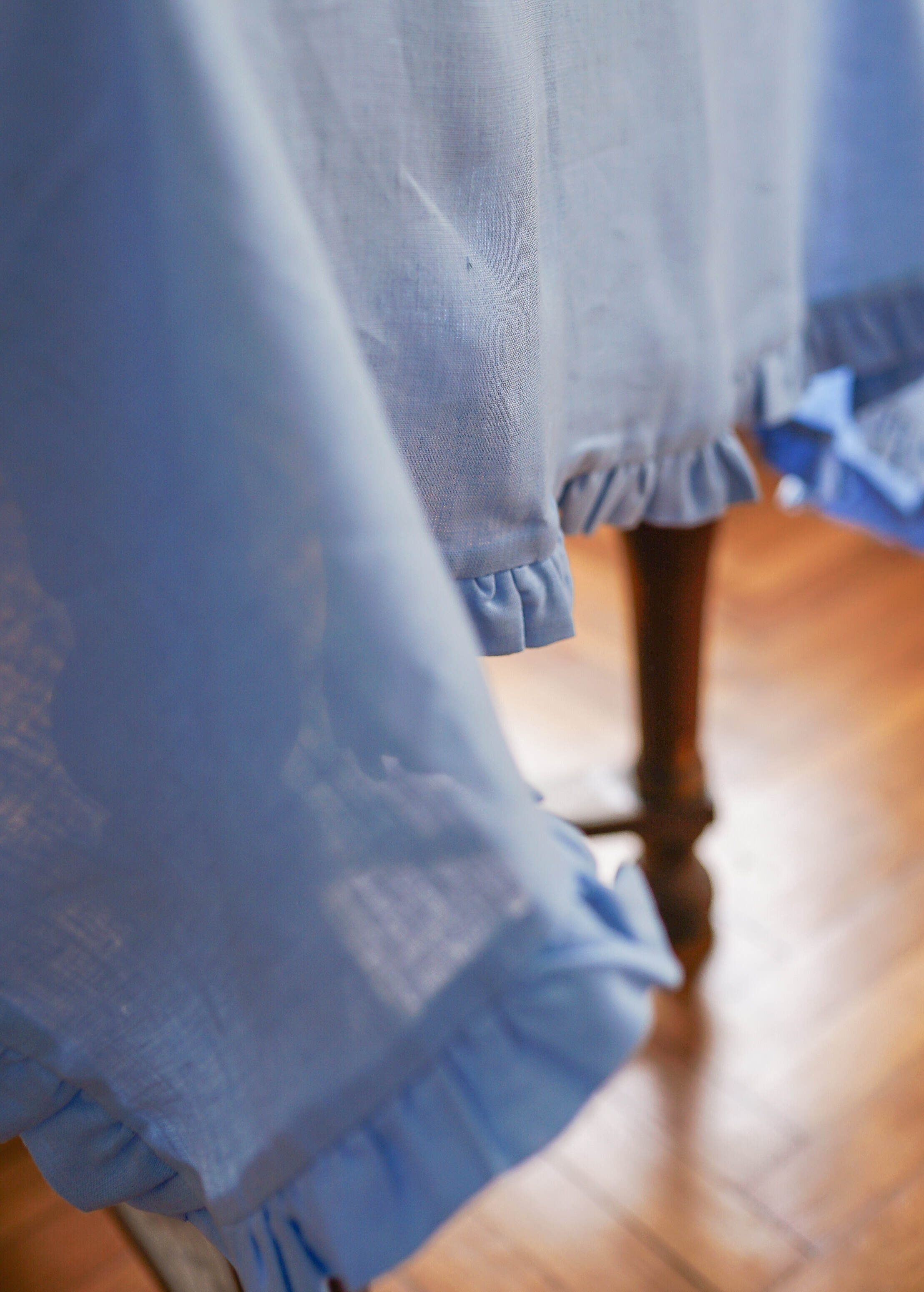 a close up of a blue curtain on a wooden floor