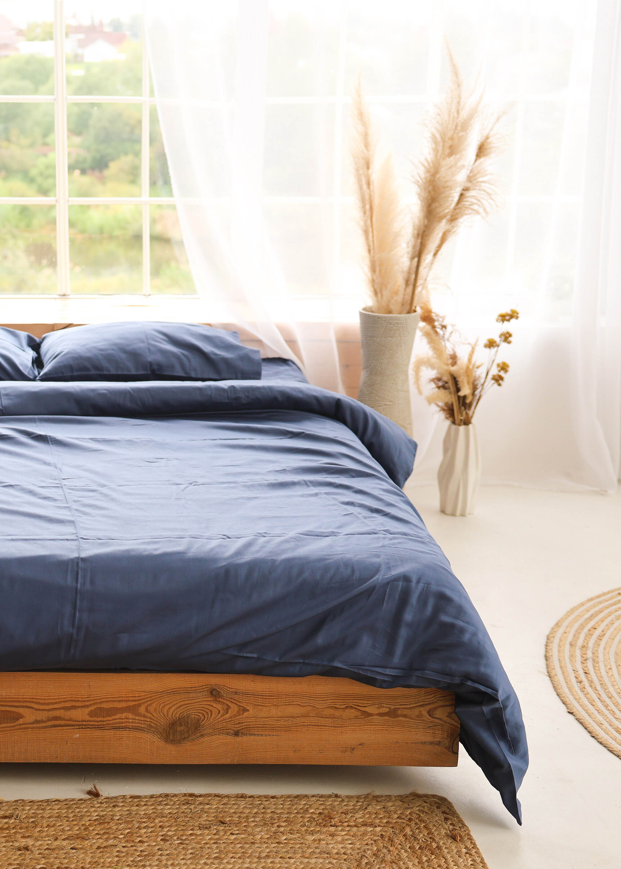 a bed with a blue comforter and pillows