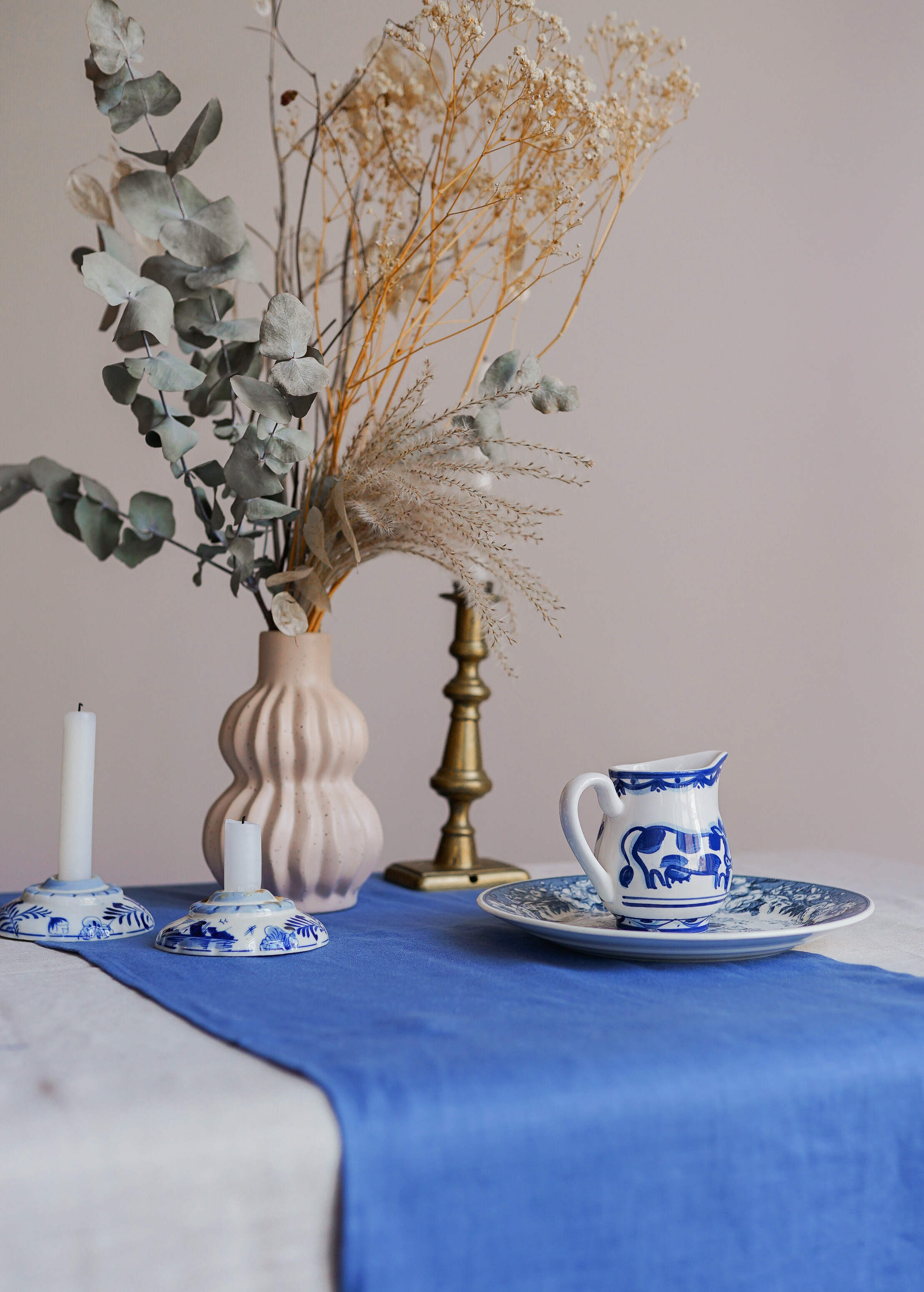 a table with a blue table cloth and a vase with flowers