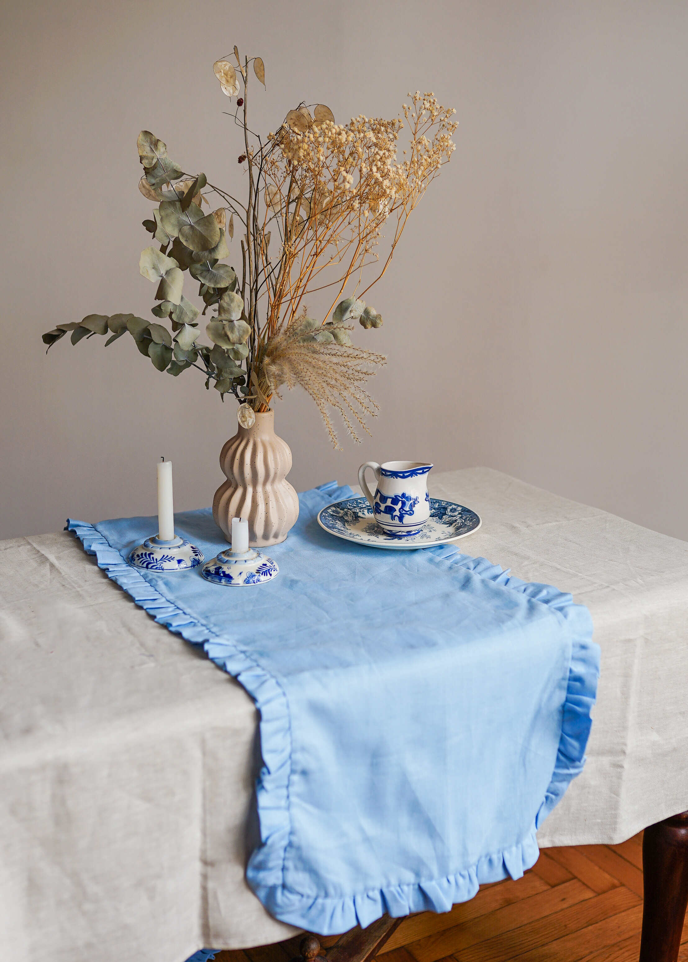 a table topped with a vase of flowers and a plate