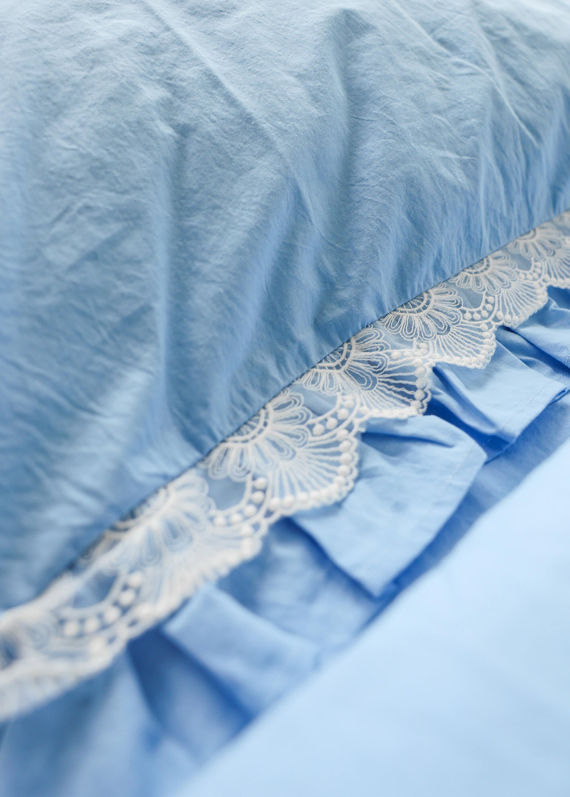 a close up of a bed with a blue comforter