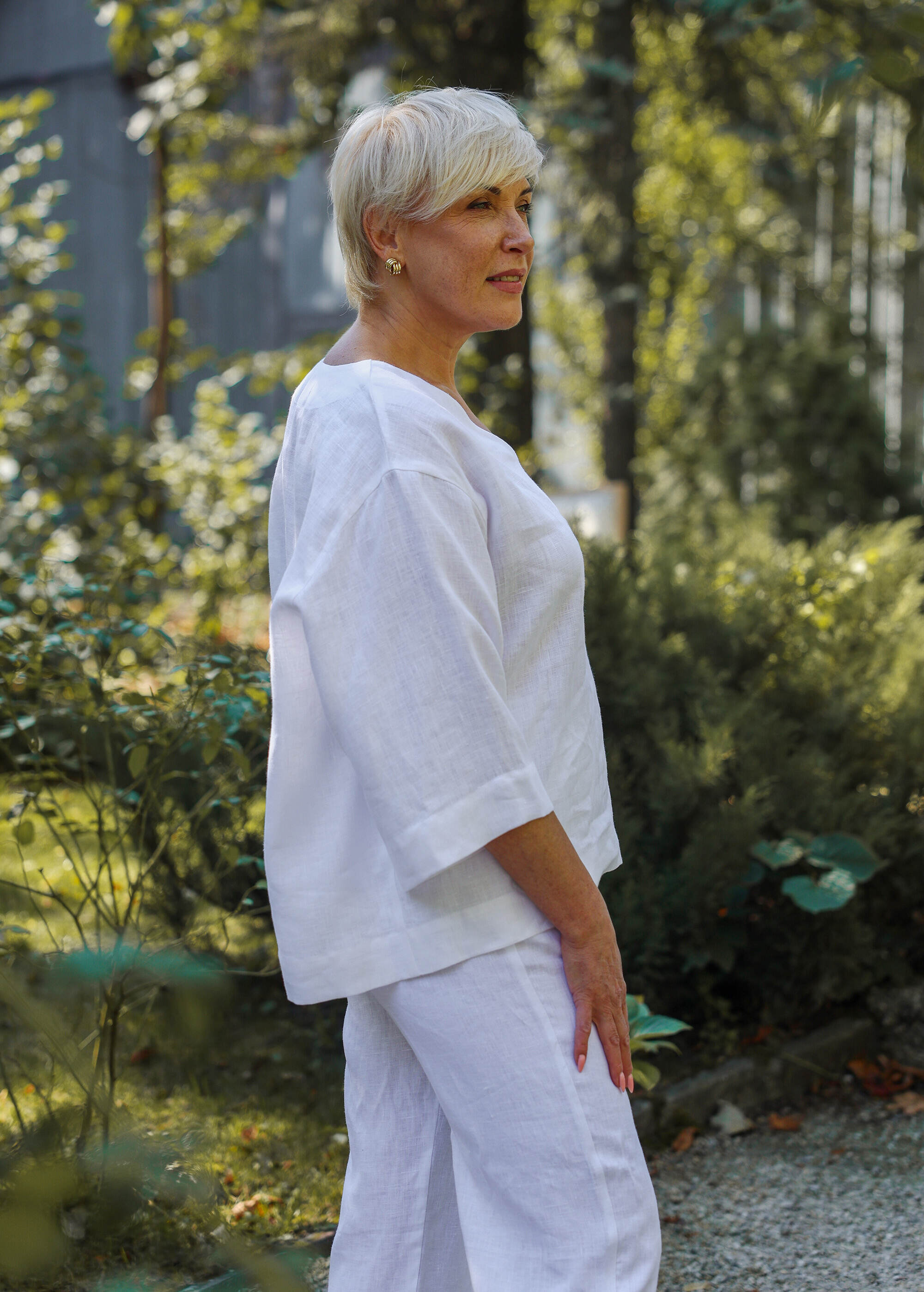 a woman in white is standing in the grass