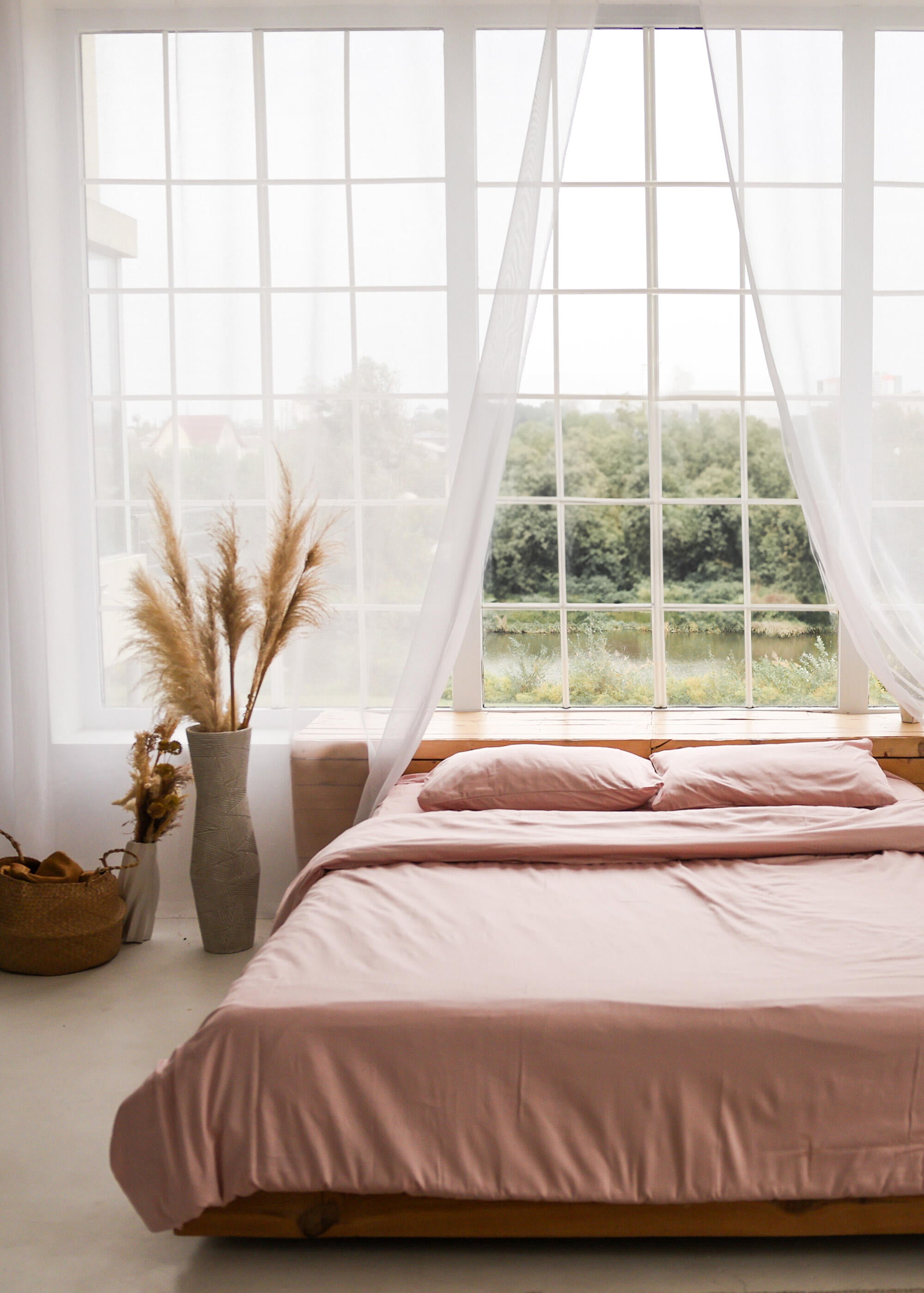 a bed with a pink comforter in a bedroom