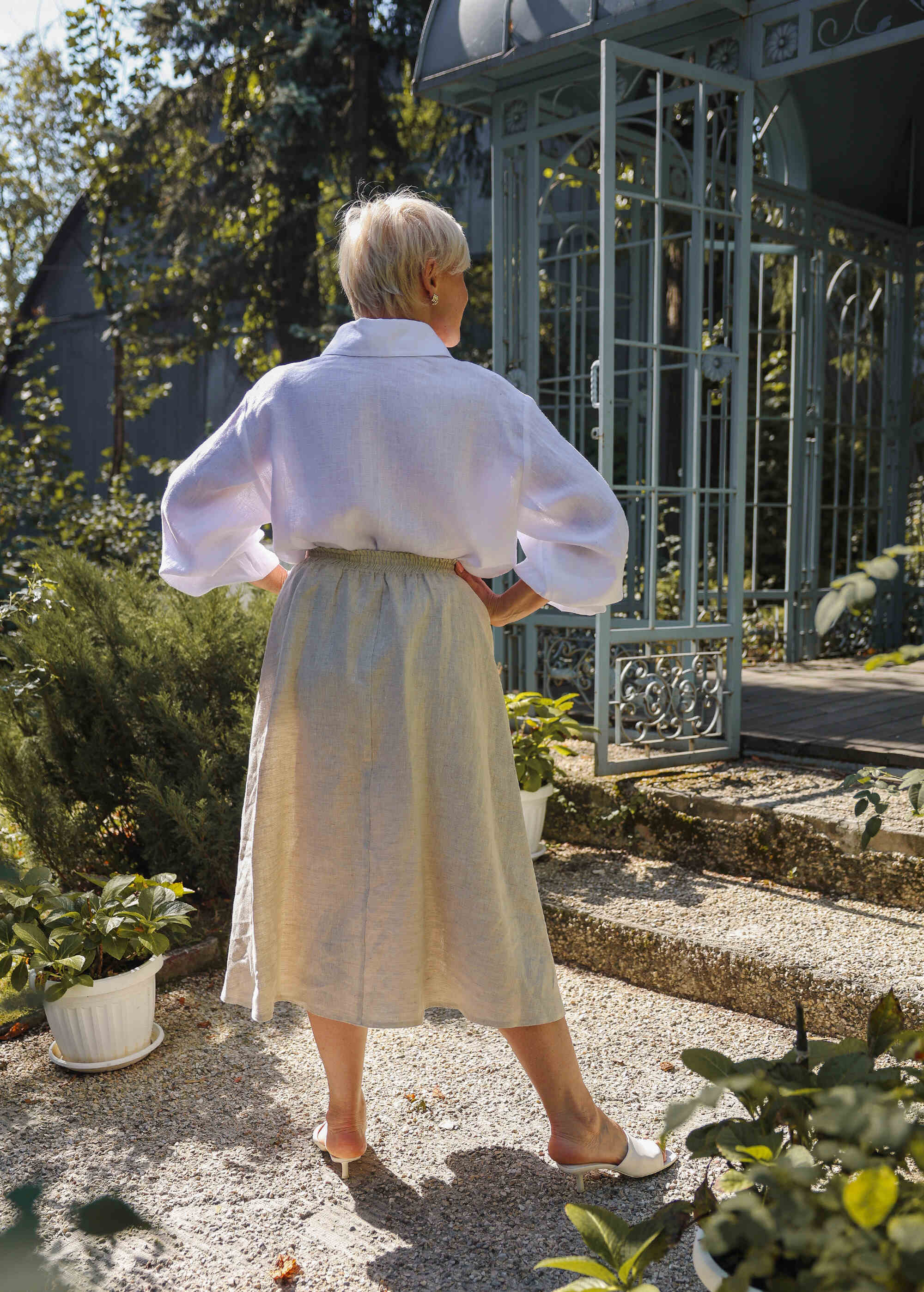 a woman in a white shirt and beige skirt