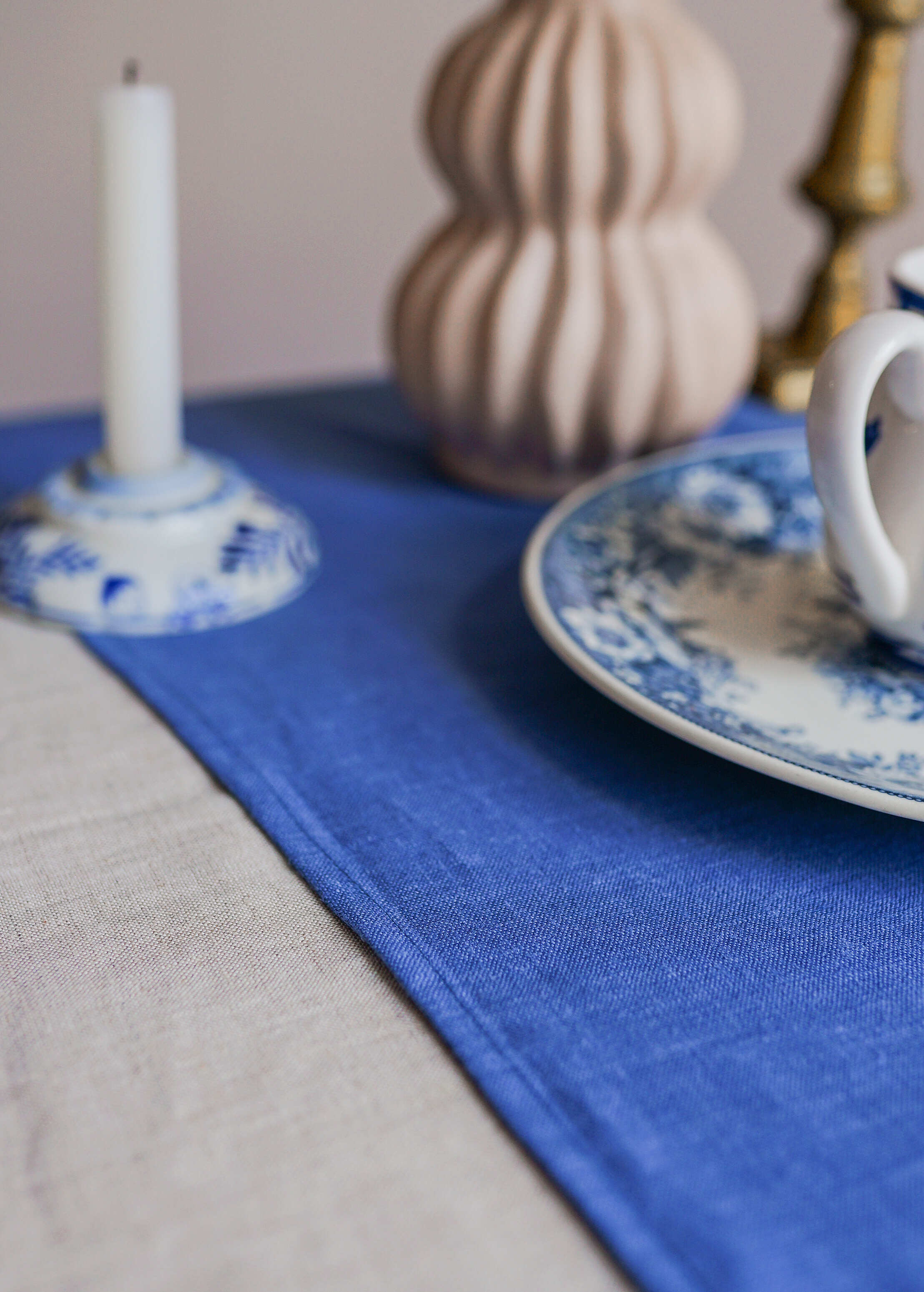 a blue and white place setting with a candle