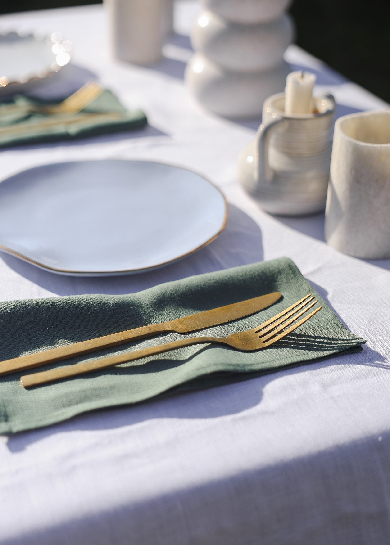 a table with a white table cloth and green napkins