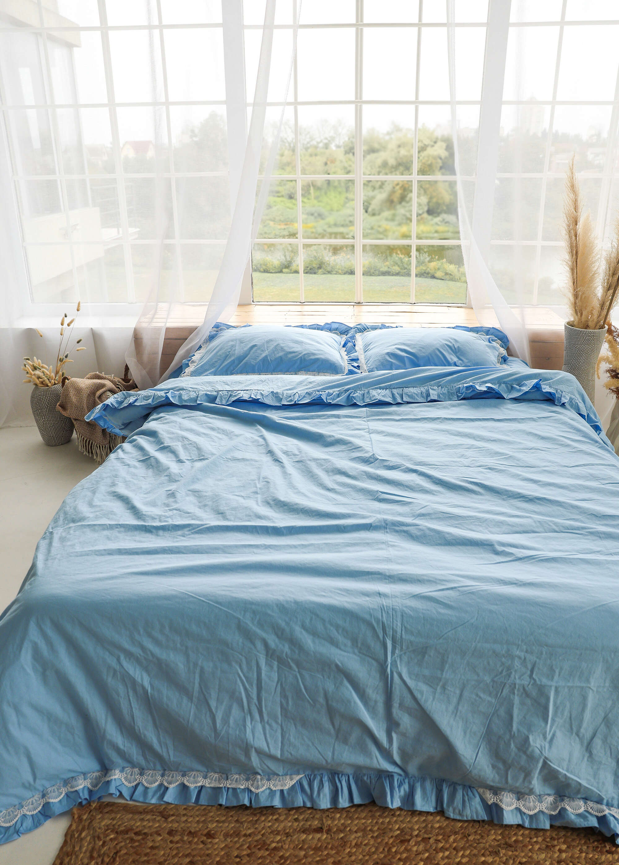 a bed with a blue comforter and pillows