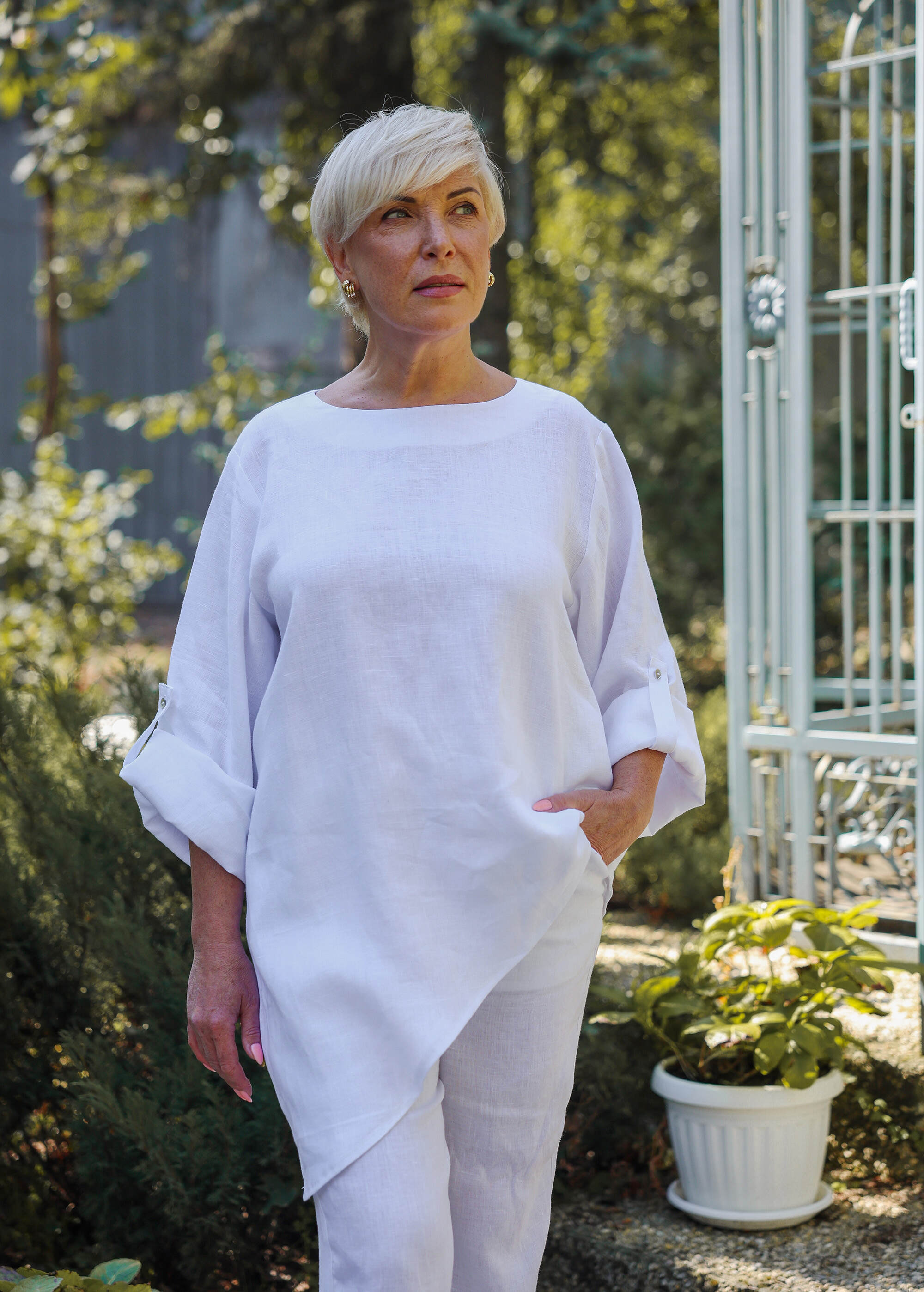 a woman is standing outside in a white outfit